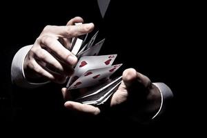 goochelaar schudt de kaarten op een toffe manier onder de schijnwerpers