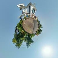 Katholiek kerk in oerwoud tussen palm bomen in Indisch keerkring dorp Aan weinig planeet in blauw lucht, transformatie van bolvormig 360 panorama. bolvormig abstract visie met kromming van ruimte. foto