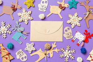 feestelijk decoraties en speelgoed Aan Purper achtergrond. top visie van ambacht envelop. vrolijk Kerstmis concept foto