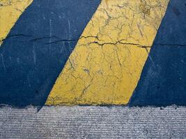 geel en zwart kleur strip net zo waarschuwing teken Aan de beton snelheid bult Aan weg foto