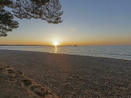 zonsondergang Aan de strand in de Kroatisch kust- stad- van fazana foto