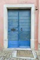 beeld van een blauw houten Ingang deur naar een gebouw met een antiek facade foto