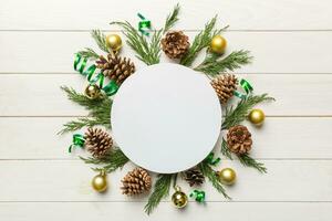 vlak leggen Kerstmis samenstelling. ronde papier blanco, pijnboom boom takken, Kerstmis decoraties Aan gekleurde achtergrond. top visie, kopiëren ruimte voor tekst foto