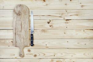 snijdend bord met mes Aan houten tafel. top visie foto