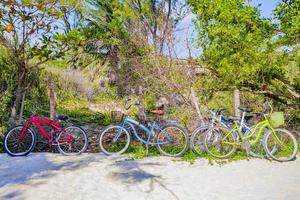 kleurrijke geparkeerde fietsen op strand playa del carmen in mexico foto