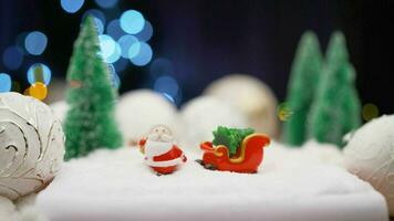 Kerstmis speelgoed- Aan slinger achtergrond. speelgoed- de kerstman claus Aan de achtergrond van licht bollen. Kerstmis achtergrond de kerstman claus met een geschenk. foto