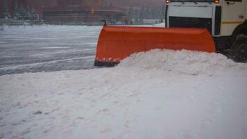 de trekker reinigt de bestrating in winter. trekker schoonmaak de weg van de sneeuw. graafmachine reinigt de straten van groot bedragen van sneeuw in stad. een emmer detailopname reinigt de trottoir van sneeuw. foto