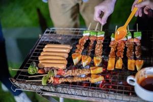 Aziatische groep vrienden met barbecue in de buitenlucht foto