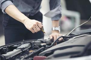 man die de motor van een auto controleert foto