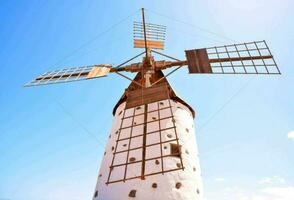 een windmolen met een houten toren en een blauw lucht foto