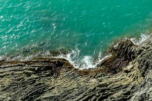 antenne visie van de oceaan en rotsen in de buurt de kust foto