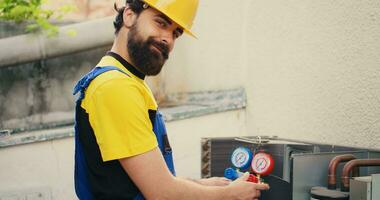 doeltreffend technicus op zoek Bij koelmiddel niveaus in extern lucht conditioner terwijl gebruik makend van verdeelstuk meter naar precies meten de druk in hvac systeem, zorgen voor doeltreffend koeling prestatie foto