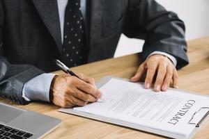 mannelijke advocaat die contract met pen ondertekent