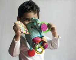 5 jaren aanbiddelijk weinig kind jongen spelen met pluche olifant speelgoed- foto