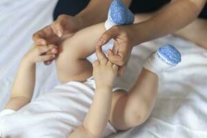 baby massage. mam aan het doen gymnastiek met kind. mama masseren schattig baby jongen. in beweging baby's poten naar helpen verlichten constipatie. jong moeder aan het doen opdrachten en bewegingen naar stimuleren baby's darmen. foto