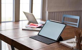 tablet leeg scherm en kantoorapparatuur op houten tafel. foto