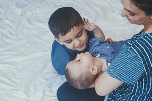 gelukkig kinderjaren concept. gelukkig broers portret. 6 jaren en 6 maanden oud jongens hebben plezier. twee weinig kinderen glimlachen hebben mooi zo tijd. schattig weinig broers aan het liegen en spelen samen foto