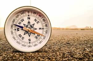 een kompas is zittend Aan de grond in de midden- van een weg foto