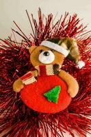 een teddy beer vervelend een de kerstman hoed en een rood ornament foto