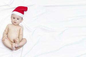 9 maand baby jongen met de kerstman claus hoed. Kerstmis ochtend. weinig kind spelen. foto