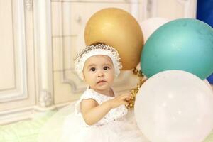 weinig prinses in wit jurk spelen met lucht ballonnen foto
