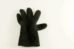 een zwart handschoen Aan een wit oppervlakte foto