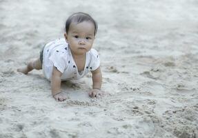 Aziatisch kleuter baby Thais meisje spelen met zand foto