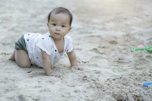 Aziatisch kleuter baby Thais meisje spelen met zand foto