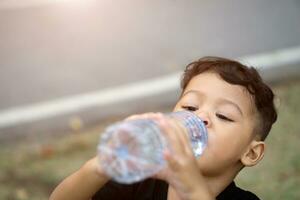 Aziatisch Thais kinderen drinken water in park foto