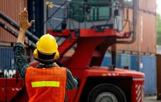 voorman is controlerend houder bezig met laden in import-export bedrijf. foto