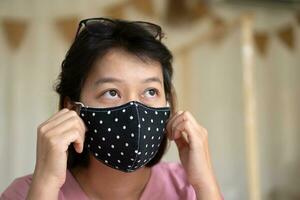 Aziatisch vrouw vervelend beschermend masker Aan haar gezicht foto