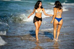 twee mooi jong vrouw hebben pret Aan de kust foto