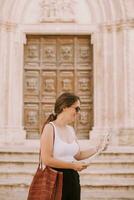 vrouw toerist met stad kaart door de kerk san francesco dassisi in ostuni, Italië foto