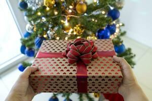 mooi gelukkig vrouw Bij huis in de Kerstmis atmosfeer tussen boom en cadeaus foto