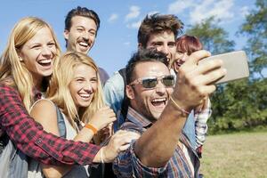 groep van glimlachen vrienden nemen selfie met smartphone foto