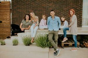 groep van jong mensen en kinderen hebben mooi zo tijd in de huis achtertuin foto