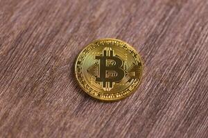 gouden bitcoin Aan houten achtergrond. crypto munteenheid, virtueel geld, internet en economie concept foto