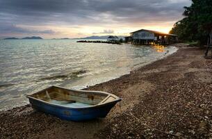 visvangst boot geparkeerd in de strand Bij zonsondergang tijd in Thailand foto