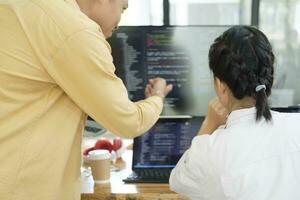 team van jong computer programmeurs samenwerken terwijl werken Aan bureaublad pc in de kantoor. foto