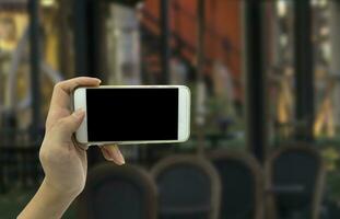 vrouw hand- shows mobiel smartphone en wazig achtergrond foto