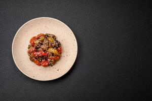 warm salade met kalfsvlees, tomaten, pepers, courgette, sesam, zout, specerijen en kruiden foto