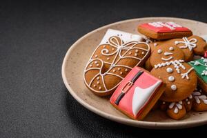 mooi Kerstmis peperkoek koekjes van verschillend kleuren Aan een keramisch bord foto