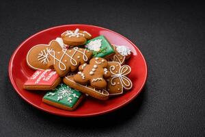 mooi Kerstmis peperkoek koekjes van verschillend kleuren Aan een keramisch bord foto