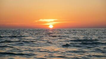 helder zonsondergang met groot geel zon onder de zee oppervlak, panorama van zee zonsondergang, zeegezicht. zonsondergang over- de zee horizon foto