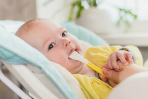 mam feeds de baby. de moeder zet een lepel van gepureerd in de kind mond. de kleuter eet voedsel. foto