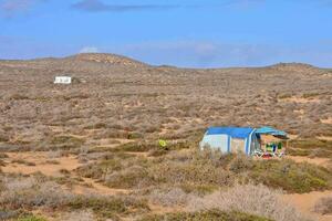 een camper tent in de woestijn met een blauw dak foto