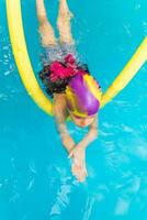 klein kind zwemmen in een binnen- zwembad. foto