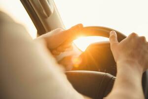 een Mens zit achter de wiel van zijn auto Aan een zonnig dag foto