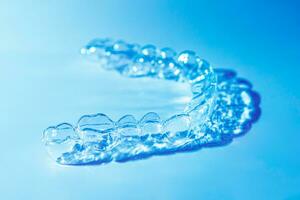 onzichtbaar tandheelkundig tanden haakjes tand aligners Aan blauw achtergrond. plastic een beugel tandheelkunde vasthouders naar rechtzetten tanden. foto