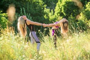 vrouw yoga instructeur onderwijs beginner in natuur Aan een zonnig dag foto